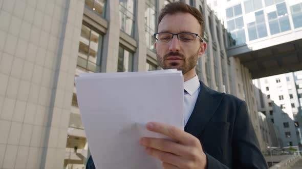 Confident Male Businessman in Eyeglasses and Formal Suit Standing Outdoors at Downtown District