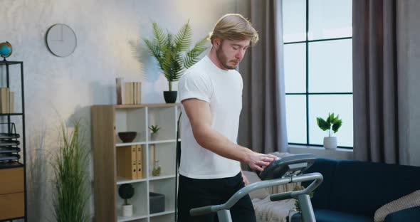 Sportive Young Bearded Man in Sportswear Jogging on Running Track in the Morning or Daytime