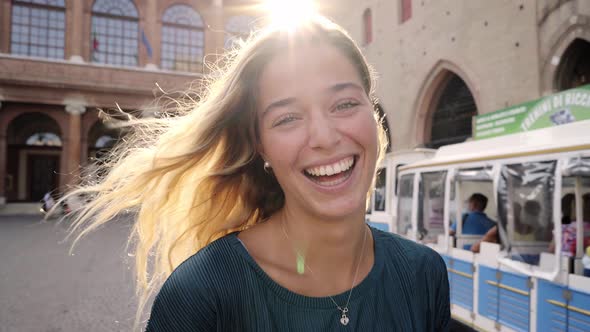 Attractive Young Woman Down the Park Turns Around with Flying Hair and Looking at the Camera