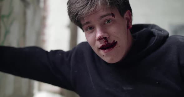 Bloodied Man Laughing at Camera and Suffering From Pain in an Abandoned Building