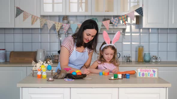Little Girl with Mom Preparing Easter Decorations