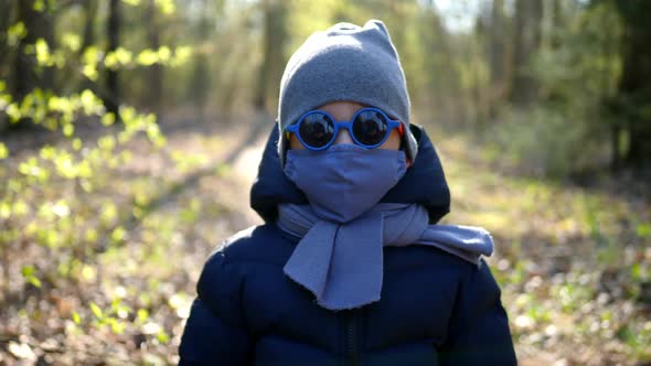 Boy Walks in a Mask Protected From the Virus and Colorful Round Glasses