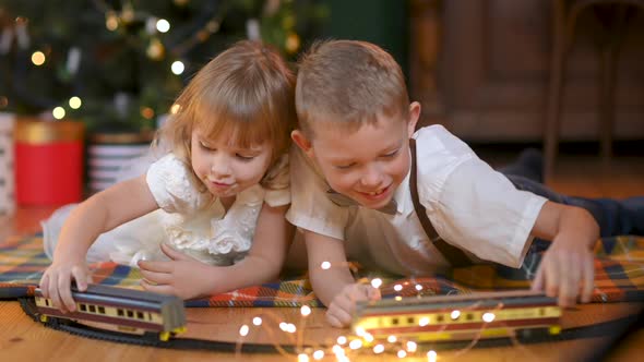 Happy children lie on the floor against the background of a festive Christmas tree