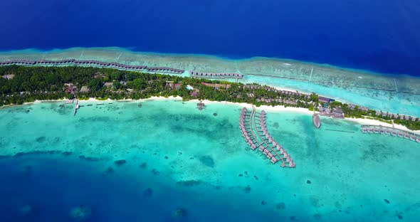 Wide angle aerial island view of a white sandy paradise beach and aqua blue water background in high