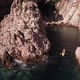 Flying behind a young man arribing with his kayak to a mediterranean cove - VideoHive Item for Sale