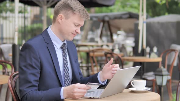 Online Shopping Failure for Businessman Sitting in Cafe Terrace