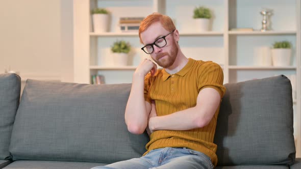 Tired Redhead Man Taking Nap on Sofa at Home 