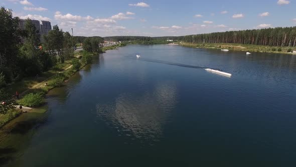 Man Wakeboarding on lake. Water Sport Activity. Cable car on the lake. Aerial, summer, sunny 02