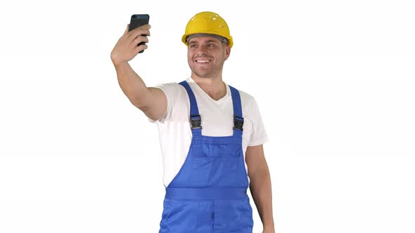 Smiling Handsome Young Builder Making Selfie with Mobile Phone on White Background