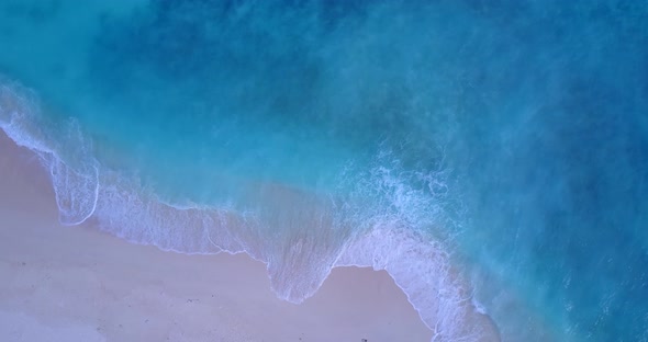 Tropical above copy space shot of a white sandy paradise beach and turquoise sea background in color