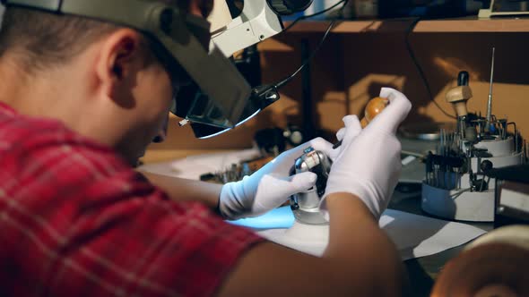 Male Craftsman Is Fixing a Ring with a Gemstone