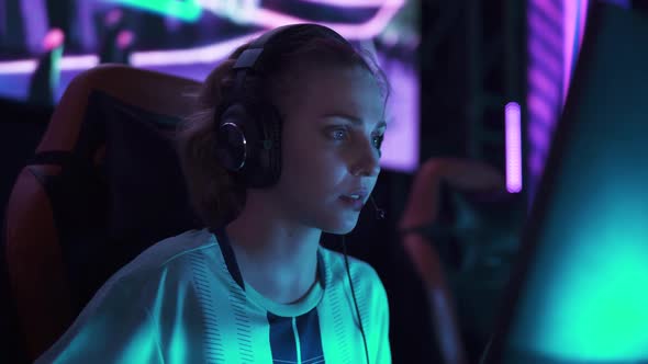 HANDHELD Portrait of an Emotional Female Gamer in Headphones Plays a Video Game Cyber Sportsman