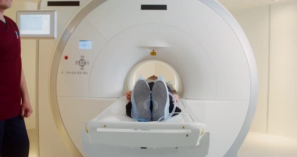 A Female Patient Leaves the Tunnel of the MRI Machine After a Brain Scan