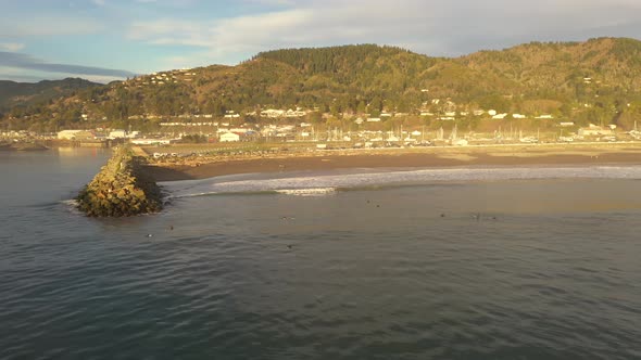 Brookings Oregon Coast. Tourist at beach and surfers in the water enjoy a warm day.