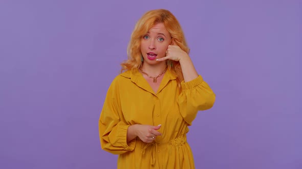 Cheerful Girl in Yellow Dress Looking at Camera Doing Phone Gesture Like Says Hey you Call Me Back