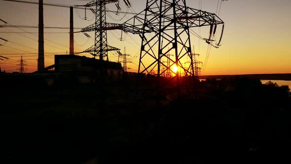 Power lines on colorful sunset. Electric post with wires with sunset background