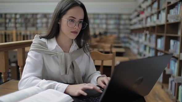 Female Student Using Laptop in Library