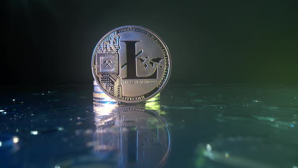 Crypto Coin Litecoin on the Glass Table with Many Water Drops on It. Close Up Panorama Shot