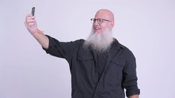 Happy Mature Bald Bearded Man Smiling While Taking Selfie