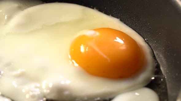 Scrambled eggs fried in a pan in oil close-up