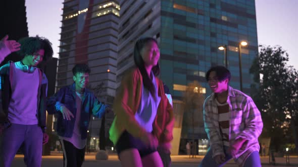 Young Asian Chinese Girl Having Fun Dancing with Group of Generation Z Friends in Music Street