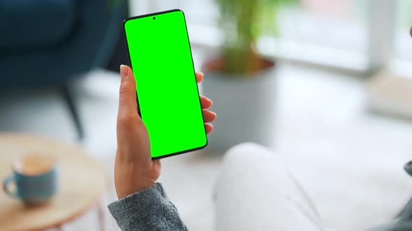 Woman at Home Using Smartphone with Green Mockup Screen in Vertical Mode