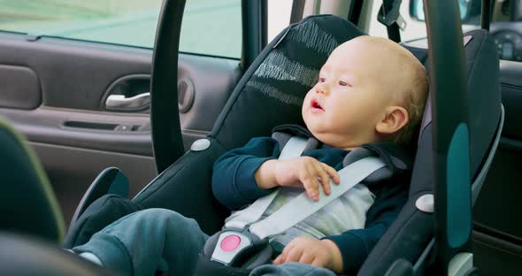 Closeup Baby Boy Sitting in the Baby Car Seat Inside of Car Mother Opens the Door Lowers the Handle