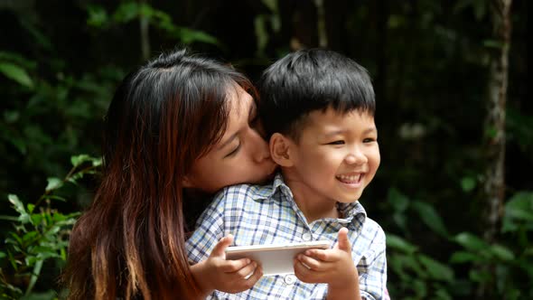 Mother and son sitting relaxed in nature.