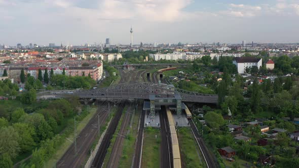 Forwards Fly Above Multi Track Railway Line with Train Station