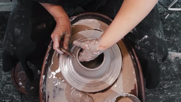 Pottery  a Woman Thinning the Sides on Wet Clay Pot on the Potter Wheel