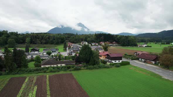 Aerial View of Green Agricultural Fields in Austria Near the Mountains in Clouds