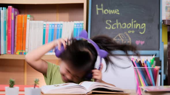 Cute little girl with headphones and tablet listening to music at home. happy childhood. alt