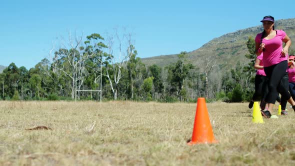 Group of women running through cones in the boot camp