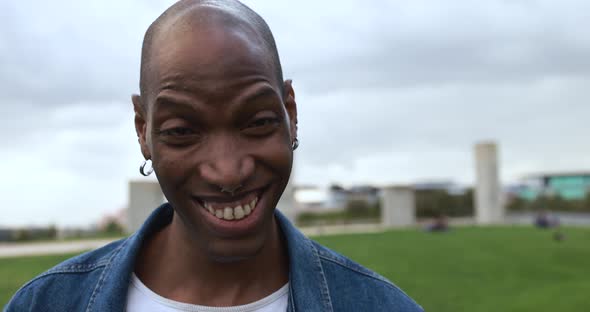 Happy african man having fun in front of camera at city park