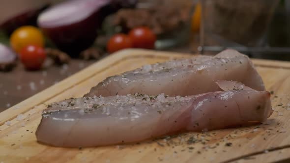 Professional Chef Sprinkles Fish Steak with Pepper