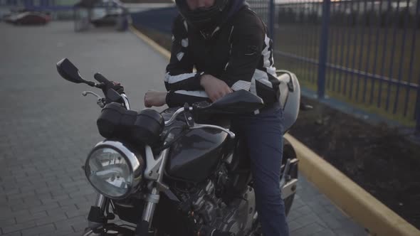 Portrait of Young Attractive Motorcyclist with Black Helmet on Street