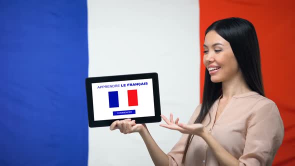 Lady Holding Tablet With Learn French App, France Flag on Background, Education