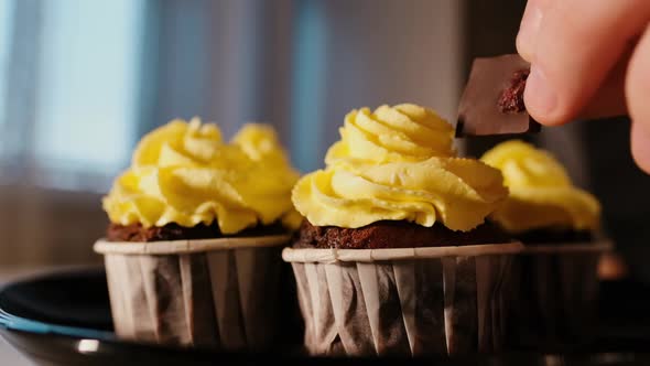 A Pastry Chef Decorates a Cupcake with Chocolate with a Bright Cheese Cream Closeup