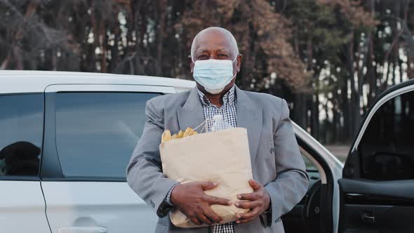 Elderly African American Man in Protective Medical Mask in Street Parking Bought Groceries in Fruit