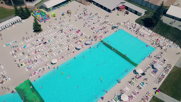 Aerial: Flying Over the Beach, a Lot of People Are Sunbathing, Swimming in the Pool