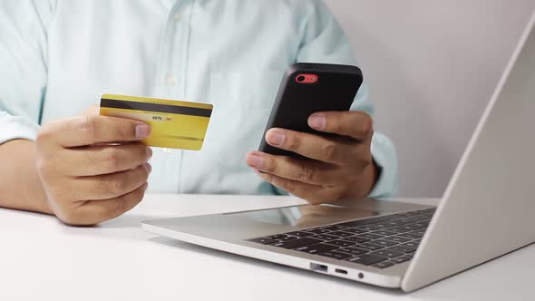 A man sat typing the credit card information on the laptop