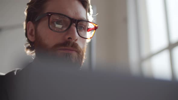 Young Caucasian Businessman in Formalwear Working on Laptop in Office