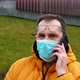 Sick Man in Medical Mask Speaks on the Phone While Sitting on a Park Bench - VideoHive Item for Sale