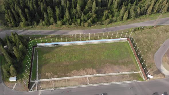 Drone view of biathlon training tracks with athletes training on skiing at offseason