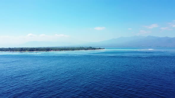 Luxury flying copy space shot of a white paradise beach and blue ocean background in 4K