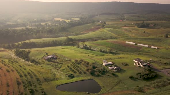 Aerial morning view of farmland in rolling hills and mountains of West Virginia.