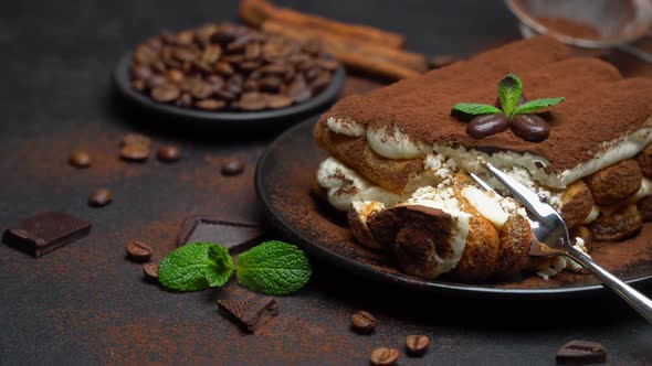 Portion of Classic Tiramisu Dessert on Ceramic Plate on Concrete Background