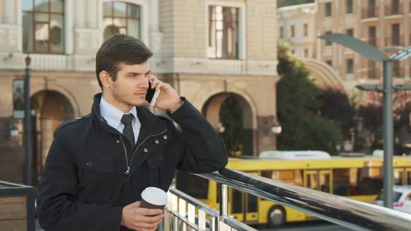 A Solid Man Stands on the Street and Speaks on the Phone