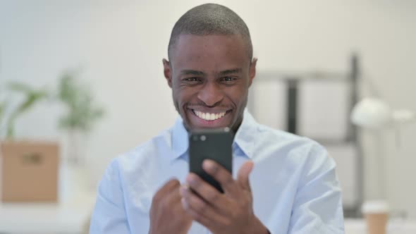 African Man Celebrating Smartphone Office