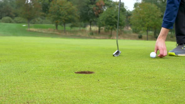 Close up of a golfer preparing for a short putt.
